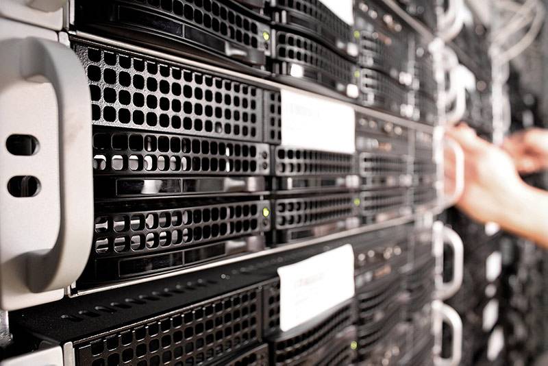 network A man's hand pulling out a server from a large rack demonstrating the need for a free network assessment from Alliance Business Technologies